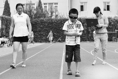 小斌斌戴着“电子眼”，在护士的指导下训练“看”路