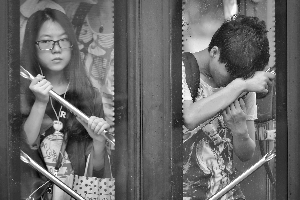 一辆公交车上挤满了乘客，有的乘客被迫贴着车门站立。有些乘客被挤到“站立禁区”。