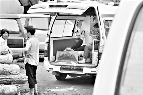 一名家属悲伤不已，在救护车上挂瓶