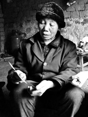 莫有文的老母亲手拿照片诉说丧子之痛