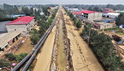 洪水将坑内的管道冲到路边。京华时报记者潘之望摄