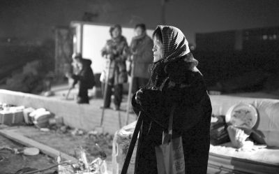 凌晨3点后，一位老奶奶呆呆地看着被搬走遗体的现场。