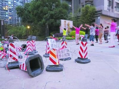 居民小区门口跳广场舞，一旁的铁丝网已被剪断