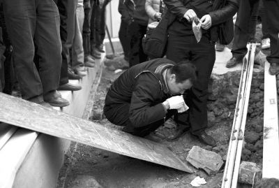 接到报警后，警方人员赶到现场提取白色手套。