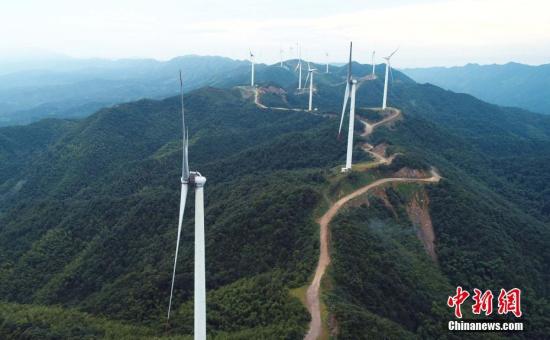资料图：风机矗立在延绵山脉迎风旋转。邓和平 摄