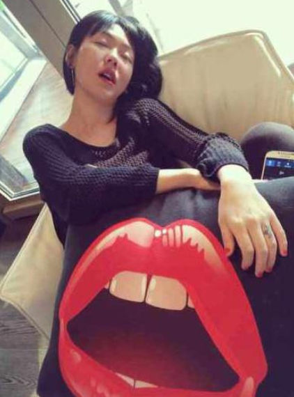 小S张嘴，与抱枕上的红唇图案神同步。