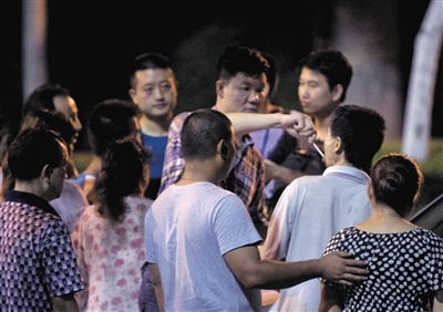 昆山市警方正给爆炸现场等待的家属取唾液做DNA比对。 周岗峰摄