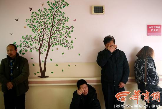 受害人两姐妹的亲属在医院的楼道里，悲痛不已。右二为受害人的父亲。