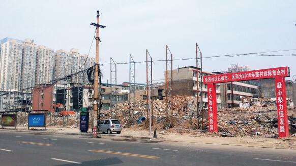 p47-1 2015 年5 月31 日，在社区干部的带头拆迁下，亲贤社区的“城中村改造”拉开帷幕。由于前期“清产核资”及补偿标准等因素，拆迁改造工作推进并不顺利。图为位于体育西路东侧集体所有的商铺率先被拆迁完毕，用于遮挡的围挡正在施工中。（拍摄2015 年9 月16 日）