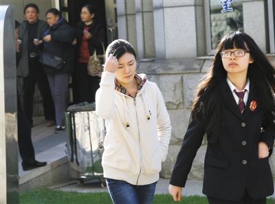 昨日下午，原铁道部运输局局长张曙光的情妇罗菲（白衣者），在书记员的带领下，准备进入法庭受审。检方指控她涉嫌掩饰、隐瞒张曙光受贿犯罪所得198万余元。庭审中，罗菲认罪，目前其处于取保候审中。 新京报记者 王贵彬 摄