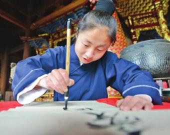 钟嗣源挥毫写下“爱国爱教和之本，上善若水道之精”