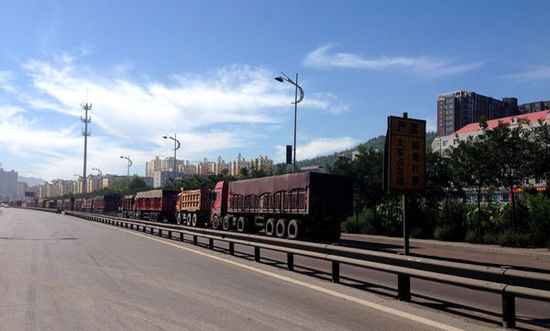 在张中生的把控下，烟雾腾腾的煤炭经济，造就了一个贪官、巨贾和骗子的江湖。图为中阳街景，运输车排长队。 澎湃新闻 陈竹沁 图