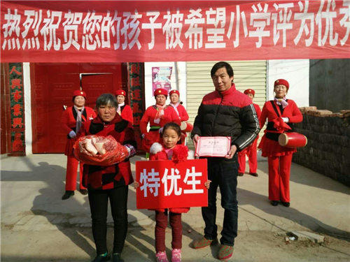 据介绍，在周口郸城县秋渠乡2016-2017学年度抽评考试中，秋渠乡希望小学综合成绩在全乡一路领先，有5人喜获“双百分”，12人喜获单科100分。为了表彰这些孩子们取得的优异成绩，学校在超市精心购买了数十个猪后臀，敲锣打鼓挨个村子给孩子们送去，并鼓励孩子们继续努力、保持成绩，健康、快乐成长。