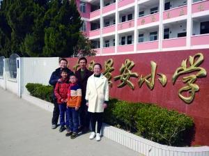 王亚飞老师和四个孩子在学校前的合影