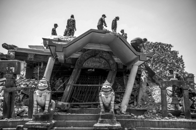 5月12日,人们在尼泊尔古城帕坦清理被破坏的景点。新华社发