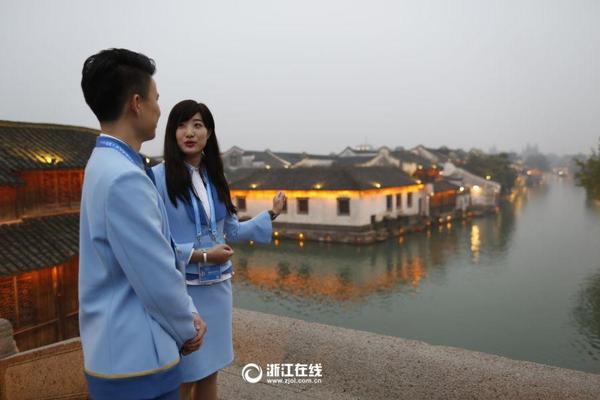 11月14日，桐乡乌镇景区，第三届世界互联网大会的志愿者“小梧桐”进行实地操练，以流利的外语接待外宾。 记者 朱卫国 李震宇 摄 图片来源：浙江在线
