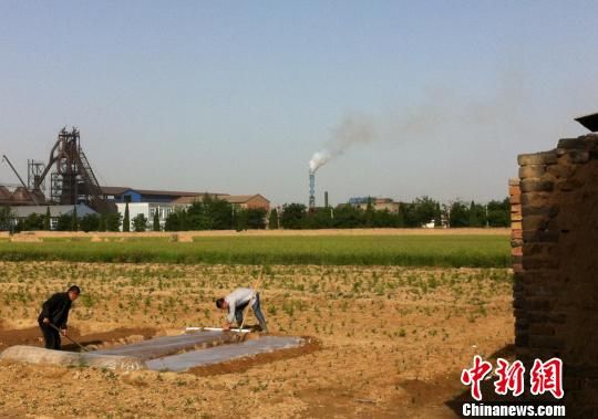 与鸿丰达铸业公司百余米之隔的便是村民的农田。 胡健 摄