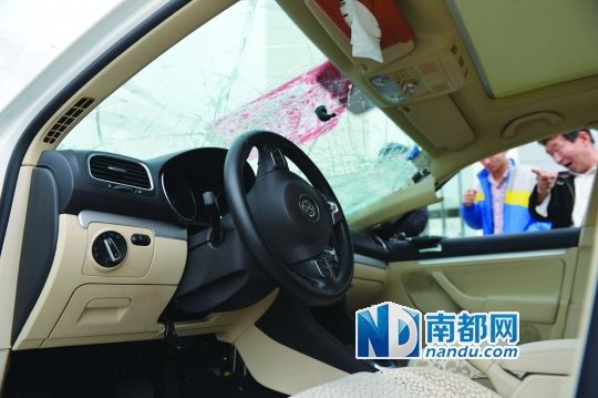 事故车副驾驶座的门完全打不开，方向盘上有血迹，车前窗玻璃有放射性裂纹。南都记者 田飞 摄