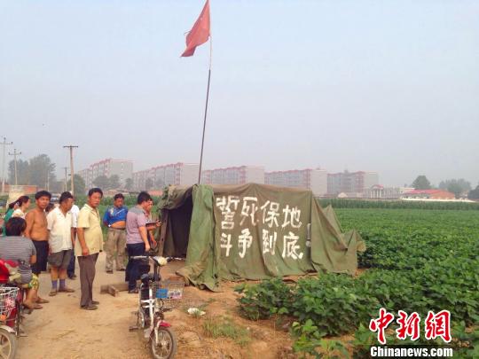 王占宾坐在医院的病床上，他刚刚做完植皮手术，腿上插满管子。　王天译　摄