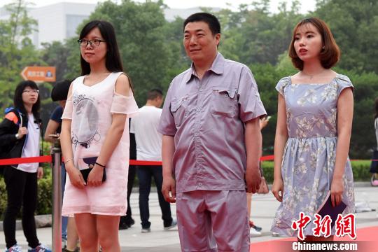 维修师傅与毕业生们一同走上红地毯。 高远 摄