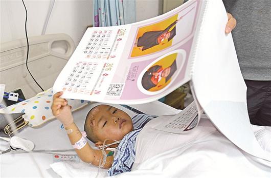 图为：看着挂历上自己受伤前的照片，小思语暂时忘记了疼痛