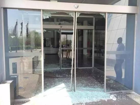 ▲被砸碎的玻璃大门有保安在把守